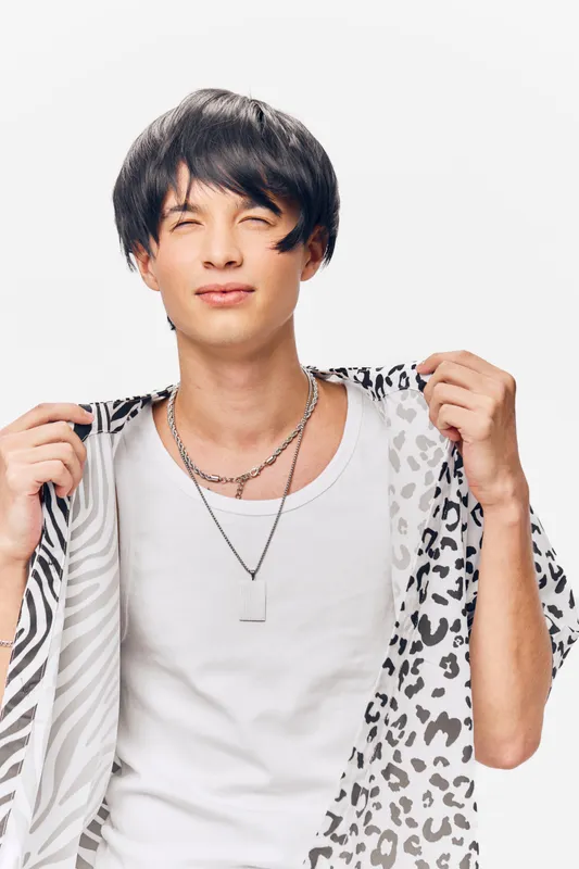 Young man wearing patterned shirt and white tank top, showing confident expression and casual style, isolated on white background, modern fashion portrait.