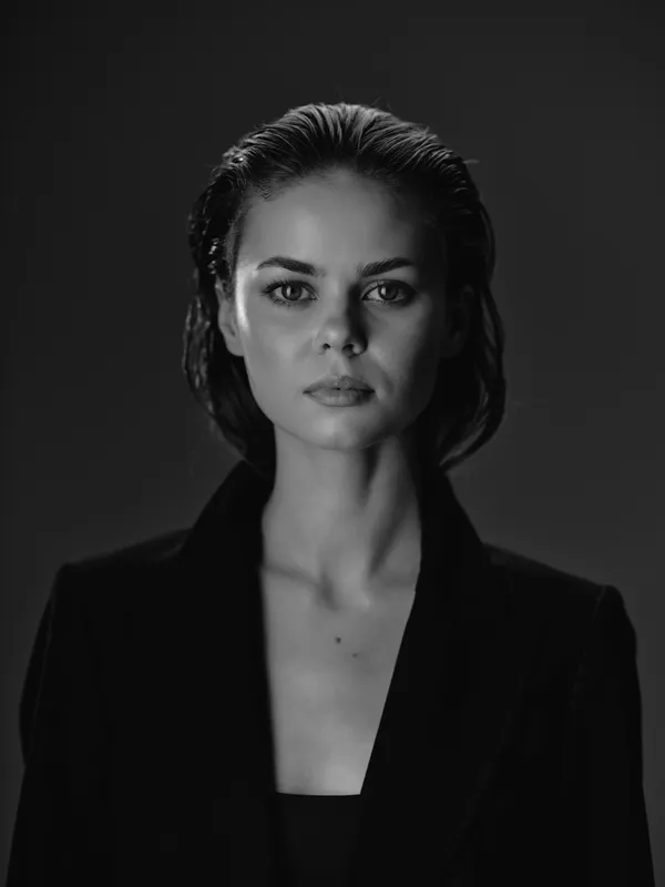 serious woman in black and white portrait with dark background and confident expression