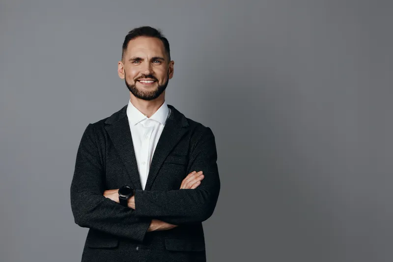 Portrait of a confident business professional man standing against a solid colored background, conveying calm leadership, a focused mood, confidence, and readiness for strategic decisions.