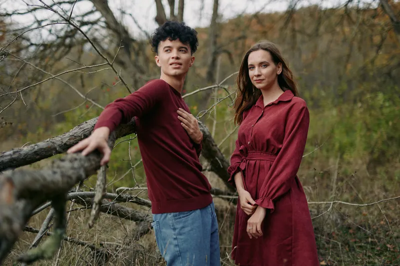 A genuine portrait of a young couple in a natural outdoor setting, conveying authentic connection and credible emotions through relaxed poses, earthy tones and honest expressions.
