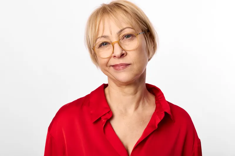Woman, glasses, portrait, studio, senior, red, blouse, smiling, close up headshot, calm expression, soft light, neutral white background, copy space, for ads