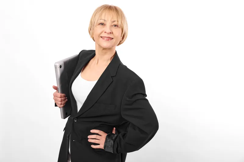 Businesswoman portrait, confident smile, holding tablet, wearing black suit, office style, standing pose on white background, professional female, clean light