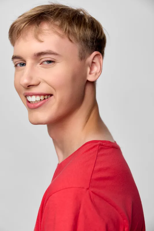 Smiling headshot of a young man in a red shirt, casual style, conveying happiness and cheerful expression for lifestyle, fashion and stock usage with a friendly tone today