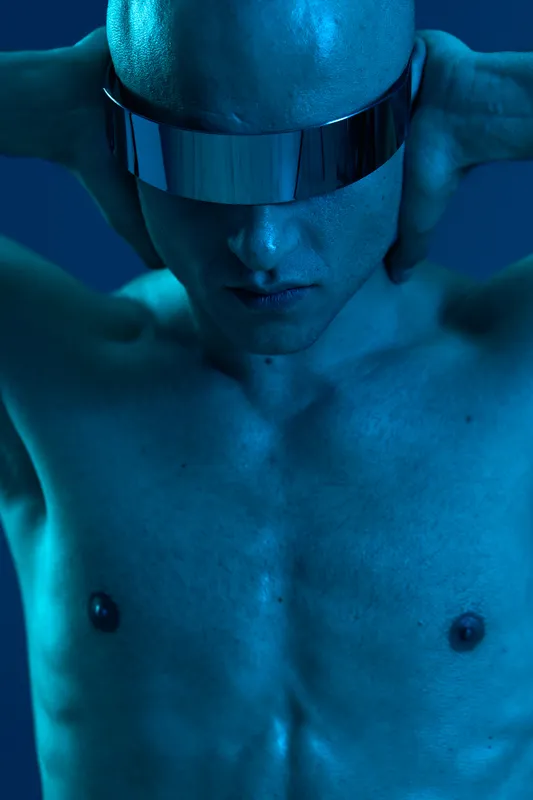 Futuristic man with stylish sunglasses, showcasing a bold expression in a blue-toned, color image. The lighting emphasizes his features and adds a modern vibe. ###