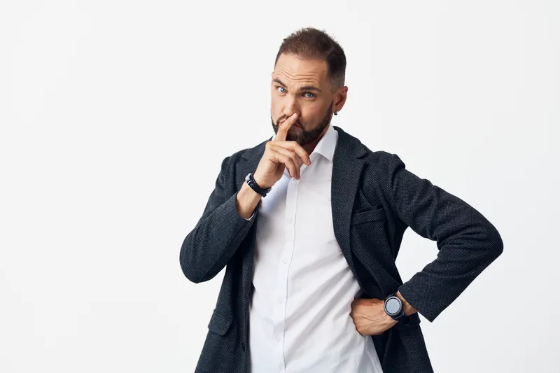 A professional business man stands against a clean colored backdrop, conveying thoughtful emotion and calm confidence, isolated in a corporate setting.