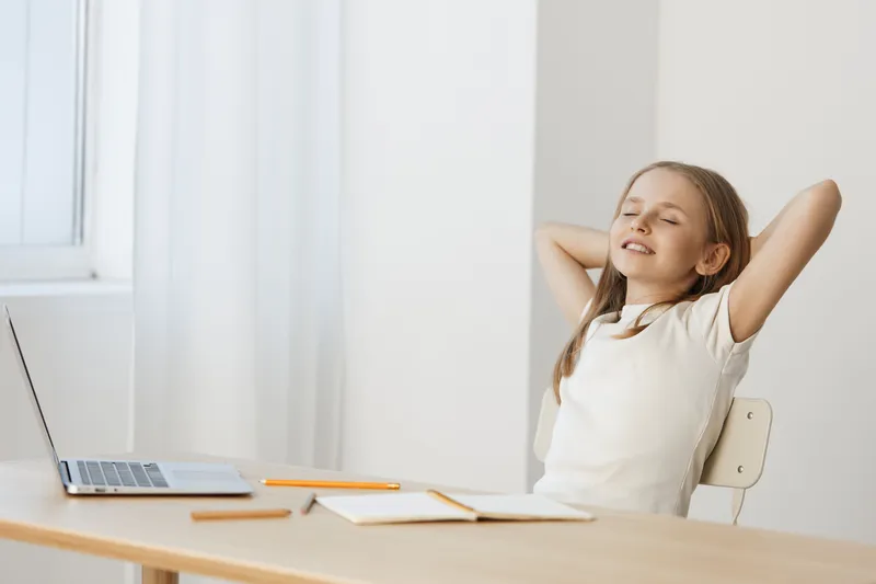 Relaxed girl enjoying free time at home, carefree expression, casual outfit, bright background, healthy lifestyle concept, creative workspace, indoor leisure