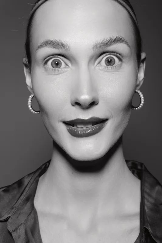Close-up portrait of a fair skinned white woman with wide eyes and glossy lips in black and white. Concept of emotions, surprise, beauty, and facial expression in studio lighting.