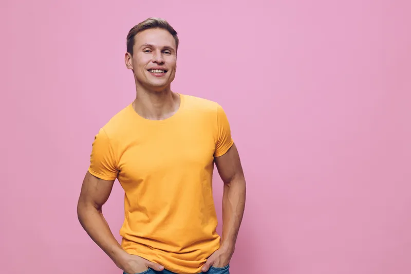 smiling man wearing yellow t-shirt standing pink background casual style cheerful confident young caucasian person digital nomad concept