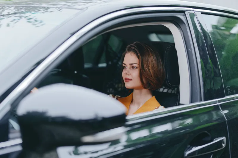 Car, driver, woman, calm a focused woman sits in the driver's seat with her hands on the wheel, ready for a journey, confident poised demeanor, modern interior, soft daylight, inviting scene
