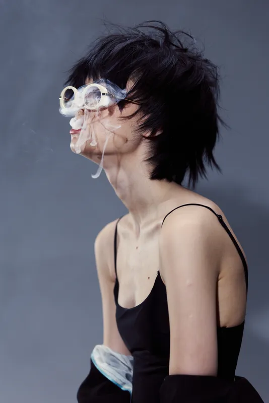 Blurred woman with black hair wearing sunglasses and black tank top, creative double exposure effect with motion blur.
