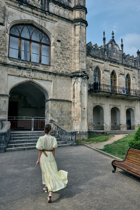 woman walking toward historic architecture and courtyard, travel exploration with authenticity and inclusivity, vintage facade and quiet
