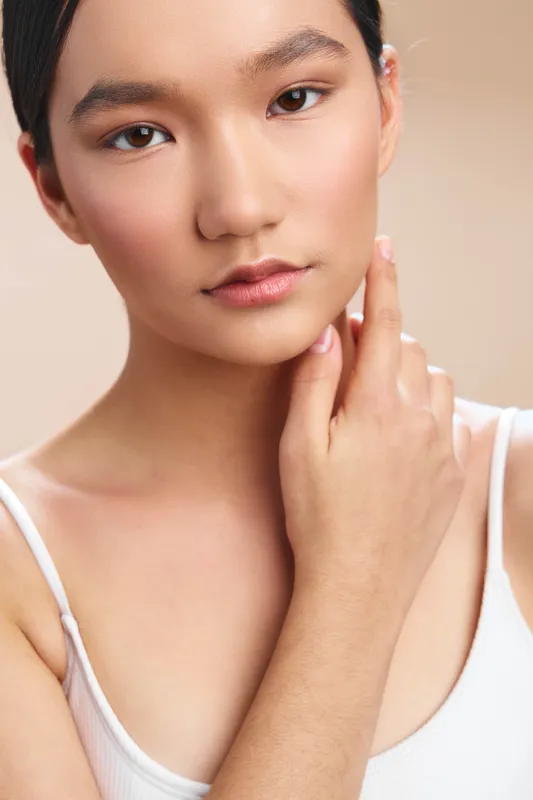 asian woman portrait in a closeup studio setting, conveying calm confidence and subtle warmth; a clean, minimal composition highlights natural beauty and graceful features.