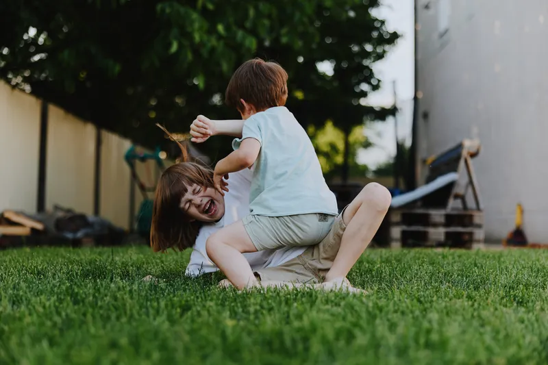 Playful children having fun outdoors, laughing and enjoying a sunny day in the garden. A joyful moment of innocence and carefree childhood spirit captured beautifully.
