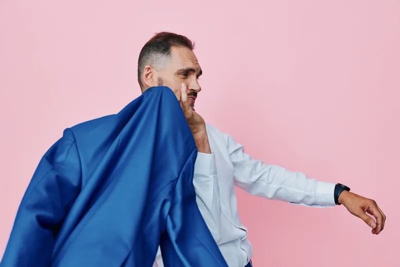 Professional man in business attire expresses confidence and emotion against a solid pink background, a clean isolated color setting that highlights focus, mood, and determination in a modern