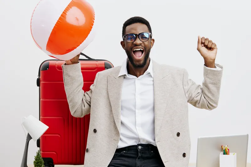 Confident joyful man with travel accessories holding beach ball smile excited positive cheerful modern casual outfit studio background. People lifestyle concept