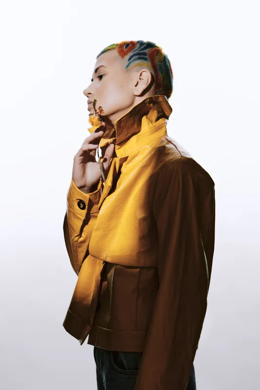 artistic woman with colorful hairstyle and yellow jacket, side profile shot, creative fashion style, modern and bold expression, unique look