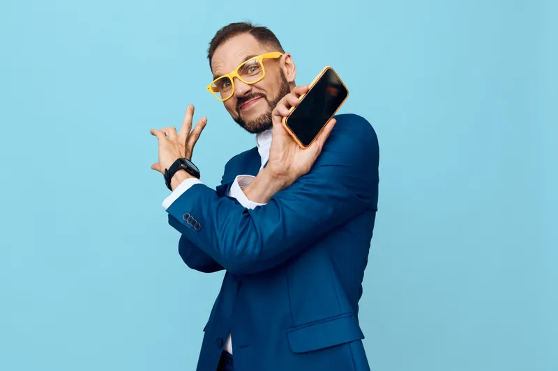 A professional businessman with a confident pose, showing focus and control, standing against an isolated blue background to highlight a polished corporate look.