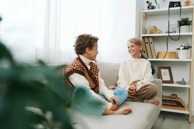 Authentic scene of children at play in a cozy living space, school themed lifestyle, curious interaction, soft textures, casual wear, and a warm, genuine mood.