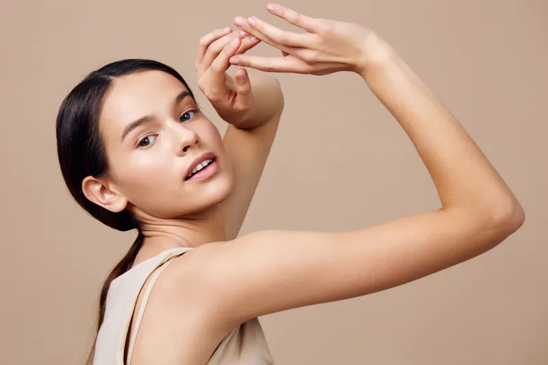 Elegant young model showcasing beauty and grace with a neutral background, emphasizing her natural skin tone and engaged expression