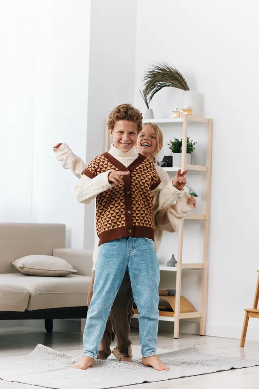 Authentic scene of playful youngsters in a cozy home, capturing a spontaneous game moment with cheerful energy and wholesome school inspired vibes