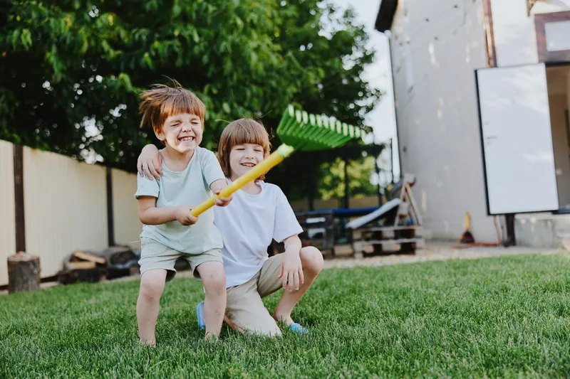 Happy children playing together in a green garden, enjoying their time outdoors with bright smiles and playful expressions, capturing the joy of childhood.