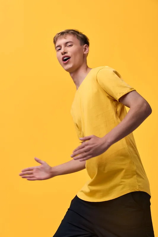 Yellow, man, movement, energetic, cheerful, casual, shirt, dance in a vibrant studio conveys energy, motion and upbeat fashion for a dynamic lifestyle and joyful performance