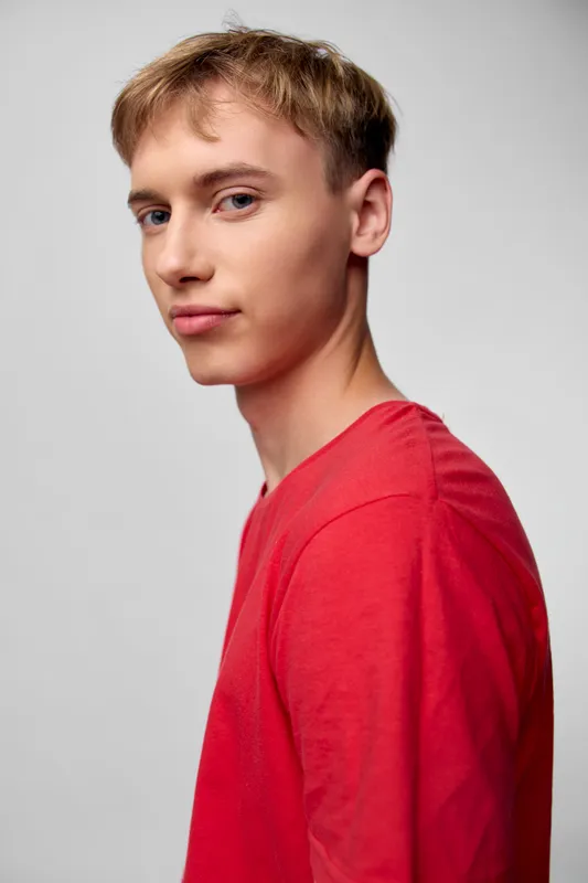 Young man, male, red shirt, studio, confident expression, casual pose, clean background, fashion, youth, model, headshot, lighting, studio lighting, soft light, gray background, casual fashion,