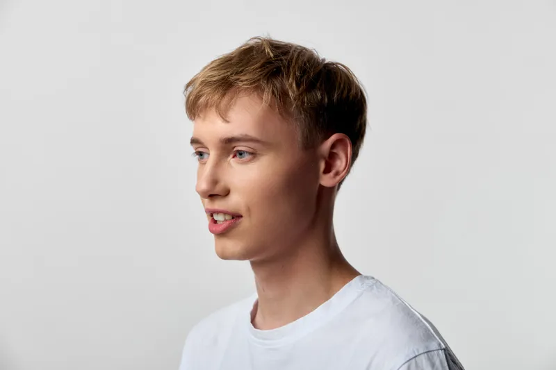 Man with light hair, smiling, wearing a white shirt, studio lighting and neutral background for a clean, versatile stock image suitable for advertising, lifestyle, fashion, or corporate creative