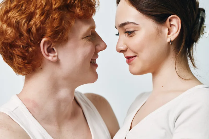 Couple, woman and man close face to face looking at each other with intimacy and smile for love and relationship. Happy two people showing affection and connection in studio.