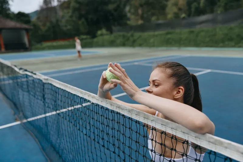 Young female tennis player preparing for a match on a sunny day, showcasing focus and determination on the court Tennis, sport, concentration, fitness, competition