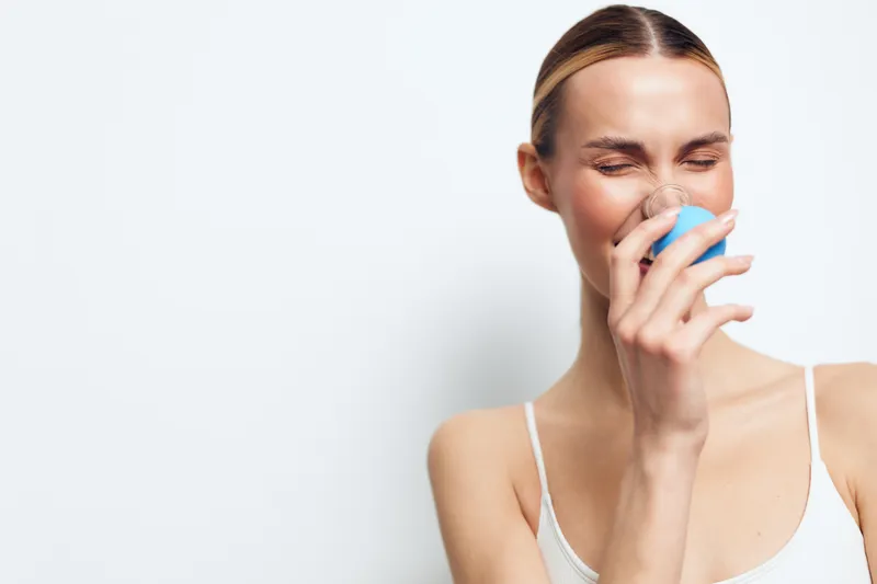 Woman drinking water, hydration for health, wellness lifestyle, holding glass near mouth with hand, fresh clean feeling, isolated on white background, copy space
