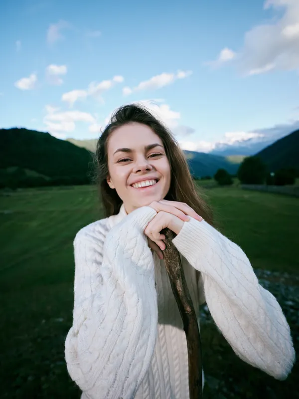 Smile, sweater, outdoors, landscape, mountains, joyful, woman, field, nature, rural, countryside, breeze, sky, sunlight, relaxed, casual, fashion, serenity, happiness, scenery, meadow, green, open,