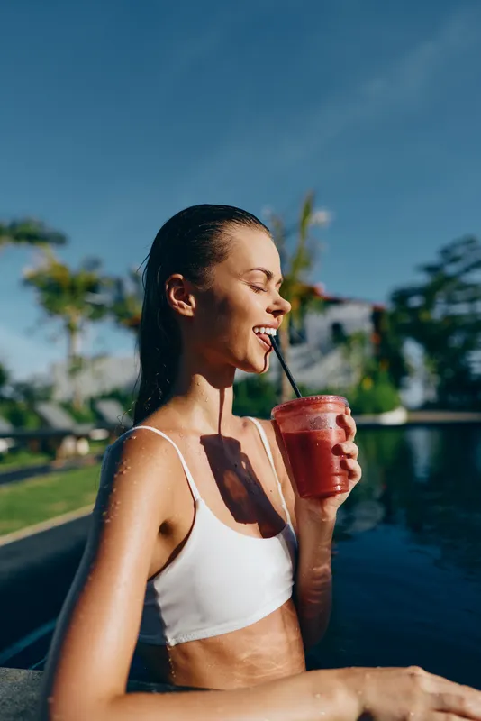 Woman pool smoothie summer outdoor hydration leisure lifestyle by poolside, sunlit scene showcasing refreshment, vitality, health, beauty, water, drink, straw influences, serene mood, vacation vibes,