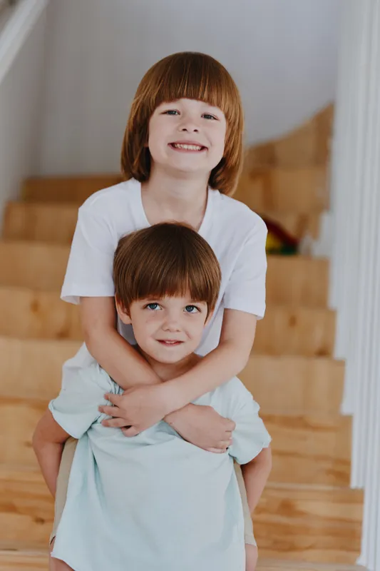 Happy children playing together indoors, showcasing joy and innocence in a bright and cheerful home environment filled with wooden accents.
