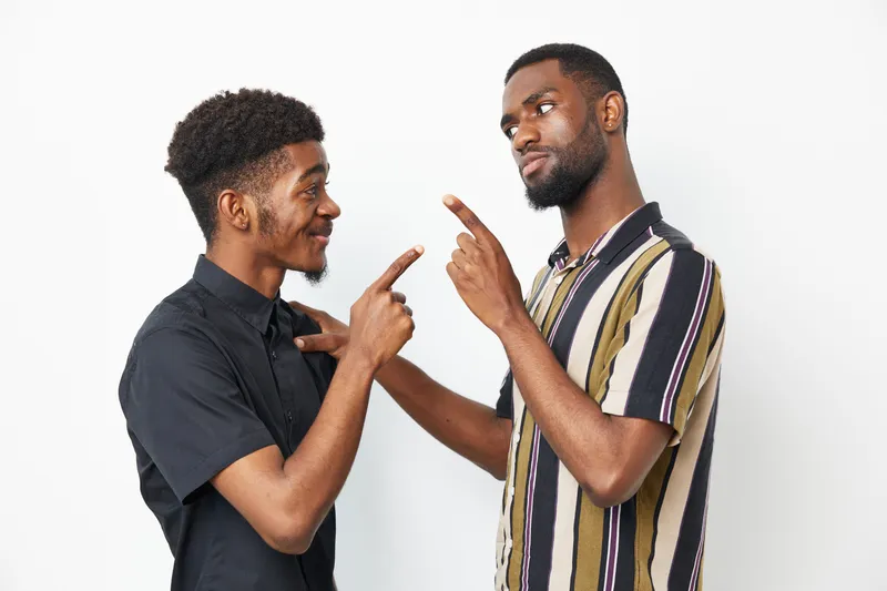 Black men engaged in a friendly conversation, showcasing joy and camaraderie. Their expressions reflect a sense of trust and understanding, perfect for representing diversity.