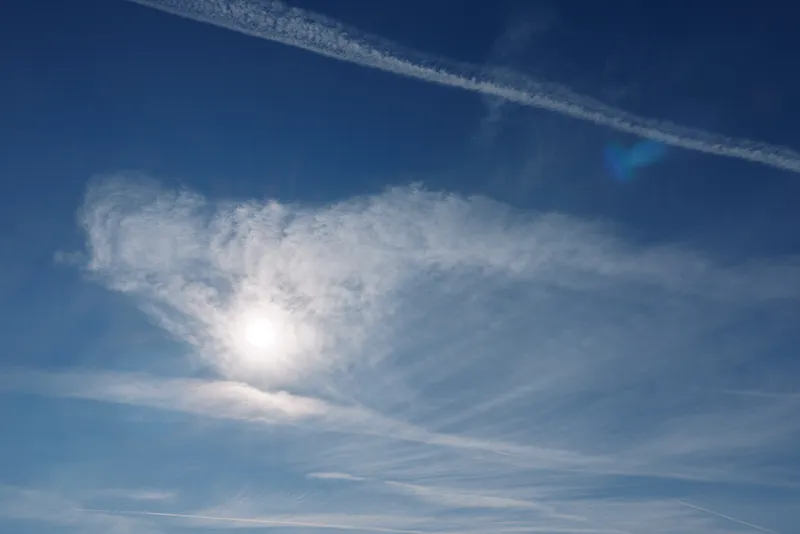 Sky with bright sun and wispy clouds against a blue daylight backdrop, a calm atmospheric scene showing clear weather and serene outdoor light for a tranquil morning impression