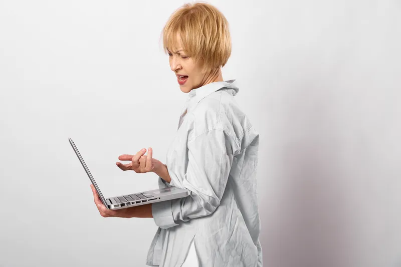 Child with laptop, education technology learning, blond boy typing on keyboard indoors, curious focused expression, modern digital study, soft even light, plain white background