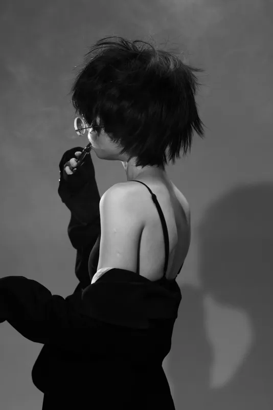Black and white artistic portrait of a woman in minimal clothing with moody lighting and vintage style.
