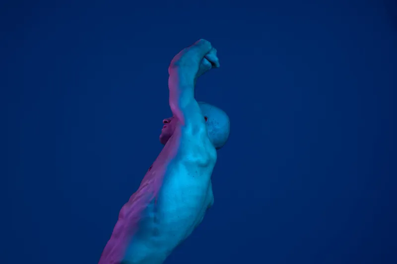 A striking figure of a man with an upward pose, showcasing the dynamic nature of human form in a blue and purple hue, capturing a sense of movement and strength.