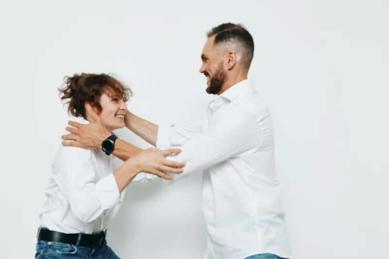 A professional business man shares a warm, confident moment with a colleague against an isolated colorful background, conveying strong emotion and teamwork.