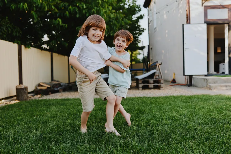 Happy children playing in the garden, enjoying sunny weather, with joyful expressions and vibrant surroundings. A perfect moment of childhood freedom.