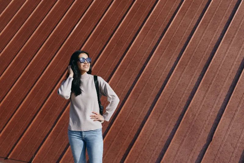 woman, sunglasses, casual, fashion, outdoor, wall, pose, denim, standing against a striped wooden backdrop with confident style and relaxed attitude in daylight