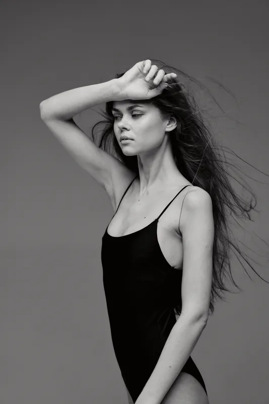 young woman posing in black dress with long hair in black and white artistic portrait