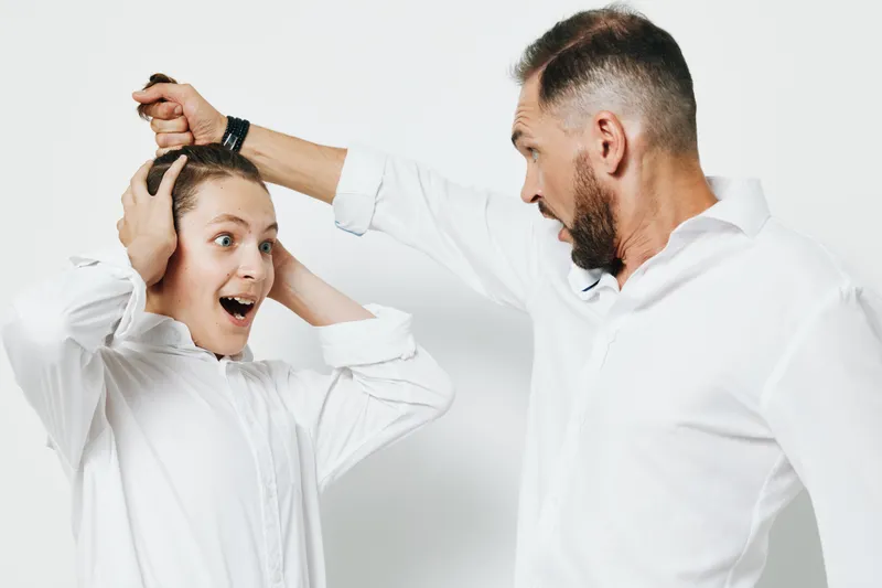 A businessman in a crisp white shirt stands against an isolated colored background, conveying a professional mood while revealing intense, bold emotion and dynamic energy.