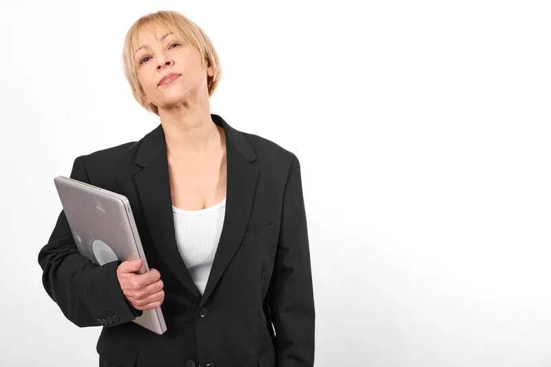 Woman businesswoman tablet technology studio portrait, neutral expression, standing in blazer, holding tablet on isolated white background for communication, corporate office work.
