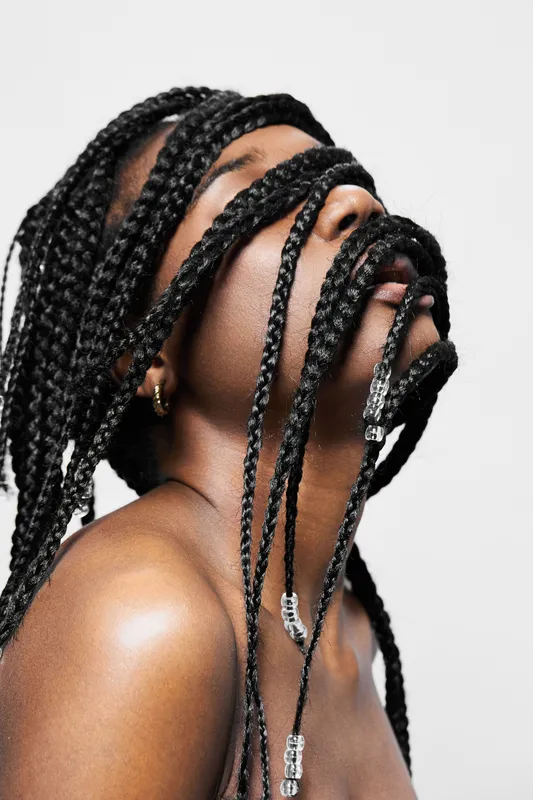 A stunning portrait of a model with long braided hair, showcasing a unique hairstyle that expresses beauty and individuality