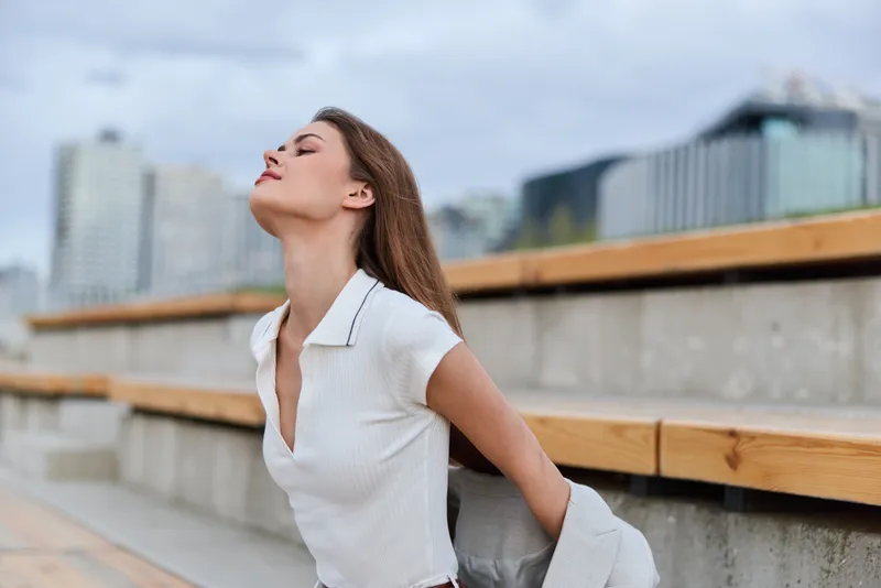 Confident business woman in casual smart attire exuding professionalism against a modern urban backdrop, showcasing empowerment and style.
