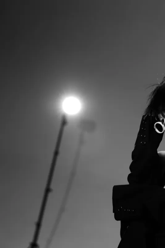Black and white portrait of a woman with glasses in dramatic lighting and elegant clothing.