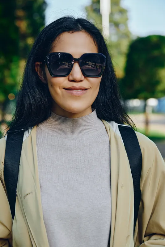 Woman with sunglasses and backpack in a sunny park, casual outdoor fashion, relaxed mood and streetwear vibe, daytime leisure vibe for lifestyle and travel photography