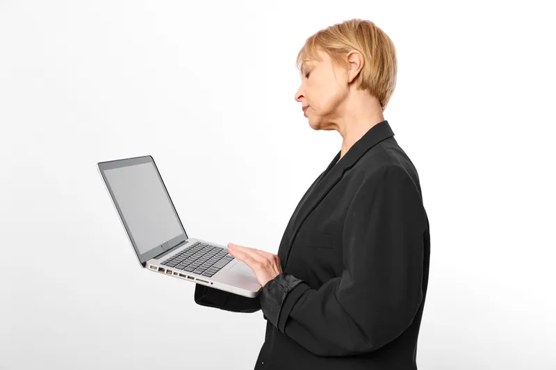 Woman business laptop computer technology work office professional manager typing at laptop in studio, white background, side profile, remote communication concept.